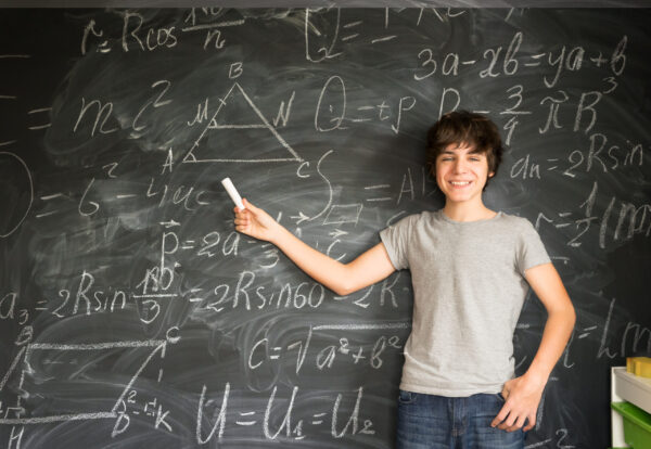 Boy writting on black board